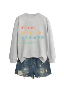 Flat lay of gray art teacher sweatshirt paired with distressed denim shorts