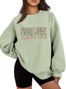 Close-up of the mint green oversized sweatshirt with printed slogan and ribbed neck