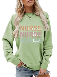 Detail view of Nurse inspire love heal print on sage green long sleeve crewneck sweatshirt
