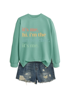 Detail of mint green sweatshirt with art teacher slogan and ripped denim shorts