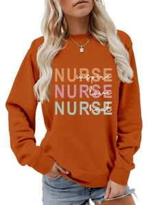 Detail of orange nurse sweatshirt with inspire love heal print and crewneck design