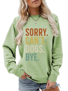 Détail de l'imprimé vintage Sorry Can't Dogs Bye sur le sweat-shirt vert clair