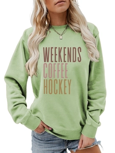 Detail of light green sweatshirt with Weekends Coffee Hockey lettering and blue jeans