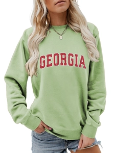 Detailed close-up of GEORGIA vintage red lettering on a light green crewneck sweatshirt