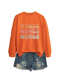 Flat lay of an orange sweatshirt with Nurse lettering and blue distressed denim shorts