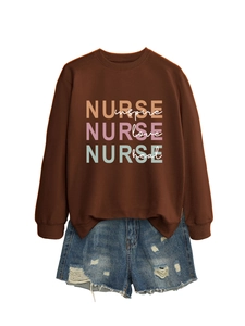 Flat lay of brown Nurse sweatshirt with colorful text paired with ripped denim shorts