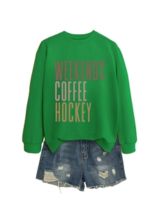 Flat lay of green crewneck sweatshirt with Weekends Coffee Hockey text and distressed shorts