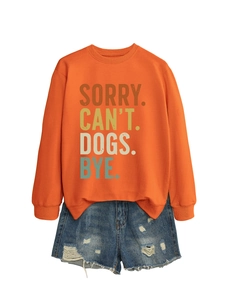 Détail d'un sweatshirt orange avec texte imprimé et short en jean aux bords effilochés