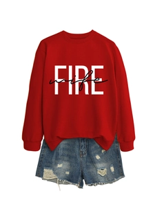 Dettaglio della felpa rossa a maniche lunghe con stampa Fire Wife e shorts in denim