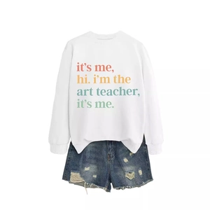 White crewneck sweatshirt with 'it's me hi i'm the art teacher' print and denim shorts
