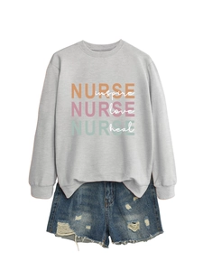 Detail of grey sweatshirt with 'NURSE inspire love heal' text and distressed denim shorts