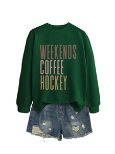 Flat lay of a green crewneck sweatshirt with coffee print and ripped denim shorts