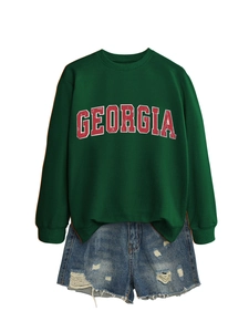 Detail of Georgia letter print on green sweatshirt paired with blue ripped denim shorts