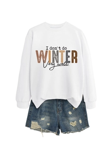 Flat lay of a white crewneck sweatshirt with colorful text and distressed denim shorts