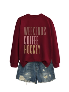 Close-up of Weekends Coffee Hockey graphic print on maroon long sleeve sweatshirt