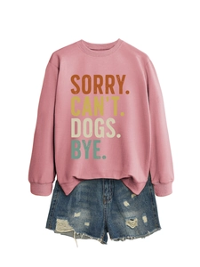 Détail d'un sweat rose avec imprimé Sorry Can't Dogs Bye et un short en jean usé