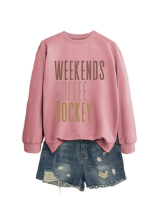Detail of pink sweatshirt with WEEKENDS COFFEE HOCKEY print and distressed denim shorts