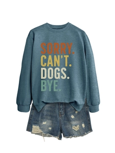 Détail du sweat-shirt SORRY CAN'T DOGS BYE assorti à un short en jean déchiré