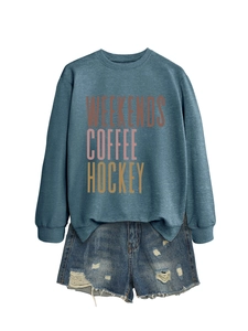 Flat lay of gray sweatshirt with Weekends Coffee print and distressed denim shorts