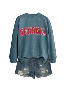 Detail of Georgia print crewneck sweatshirt paired with distressed denim shorts