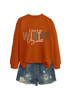 Detail view of orange graphic sweatshirt with I don't do winter slogan and ripped denim shorts