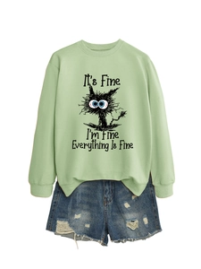 Detail of light green sweatshirt with cat print and distressed denim shorts on white background