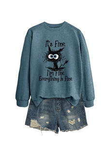 Flat lay of blue sweatshirt with black cat graphic and distressed denim shorts