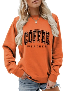 Close-up of Coffee Weather letter print on orange crewneck sweatshirt fabric texture
