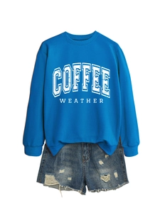 Close-up of blue coffee weather sweatshirt and distressed denim shorts with frayed edges
