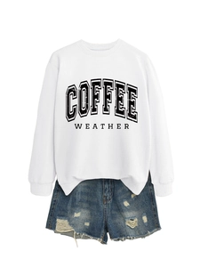 Detailed flat lay of white long sleeve sweatshirt and distressed denim shorts outfit