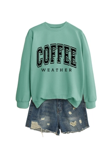 Detail of mint green sweatshirt with Coffee Weather print and distressed denim shorts