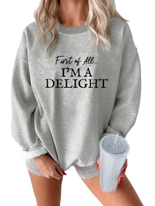 Close-up of First of All I'm a Delight text print on gray fleece sweatshirt fabric