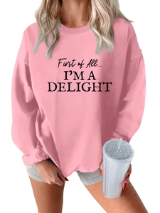 Detailed close-up of pink oversized sweatshirt featuring black letter print design