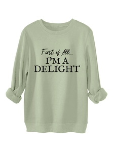 Detail of sage green crewneck sweatshirt with black First of All I'm a Delight lettering