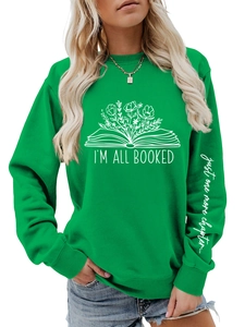 Détail de l'imprimé 'just one more chapter' sur la manche du sweatshirt vert