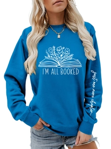 Détail de l'imprimé fleur livre blanc et texte sur manche du sweat bleu roi à manches longues