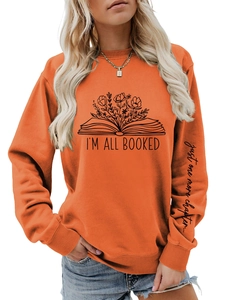 Détail de l'imprimé graphique livre blanc et texte sur sweat-shirt orange à manches longues