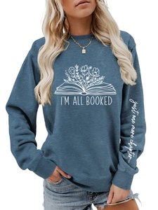 Détail du sweat bleu avec texte 'just one more chapter' imprimé sur le poignet de manche