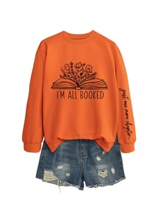Détail d'un sweat à manches longues orange avec motif livre et texte sur la manche