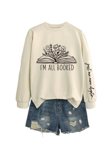 Détail de l'imprimé sur la manche 'just one more chapter' sur un sweat crème