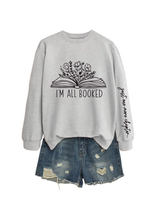 Détail du sweat gris avec imprimé floral de livres et texte 'just one more chapter' sur manche