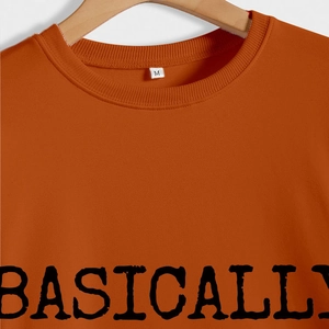 Gros plan d'un sweat-shirt caramel avec imprimé BASICALLY et col rond à côtes fines