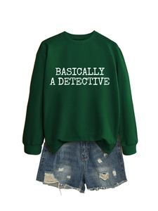 Sweat-shirt vert foncé avec texte blanc posé à plat avec un short en jean déchiré tendance