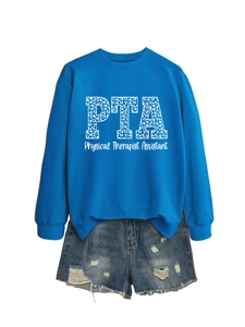 Détail du lettrage PTA avec imprimé léopard bleu sur un sweat à manches longues