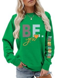 Détail du sweat-shirt vert avec une impression de slogan motivant sur la manche