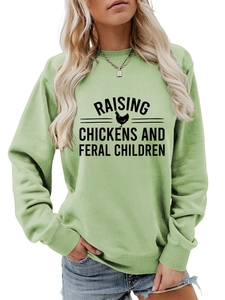 Détail du sweat vert clair avec le slogan Raising Chickens and Feral Children