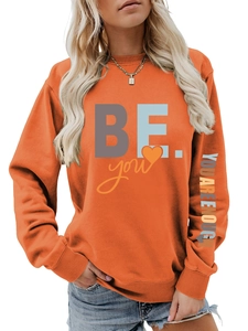 Détail du sweat à col rond orange avec imprimé coloré sur la manche et le torse