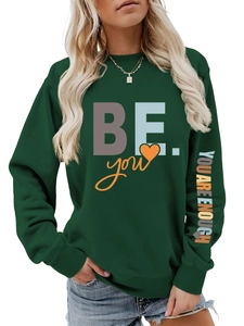 Détail du sweat-shirt vert foncé avec l'imprimé YOU ARE ENOUGH sur la manche longue