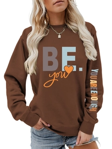 Détail du sweat marron avec slogan coloré imprimé sur les manches et la poitrine