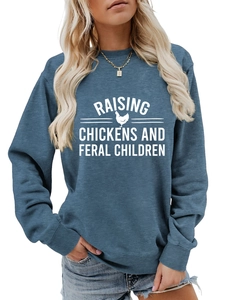 Détail du col rond côtelé et de l'imprimé graphique blanc sur un sweat-shirt bleu